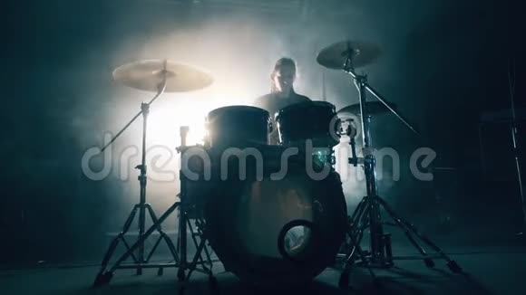 黑暗工作室里有一个男人在排练鼓声鼓组鼓包在黑暗中鼓手演奏音乐会视频的预览图