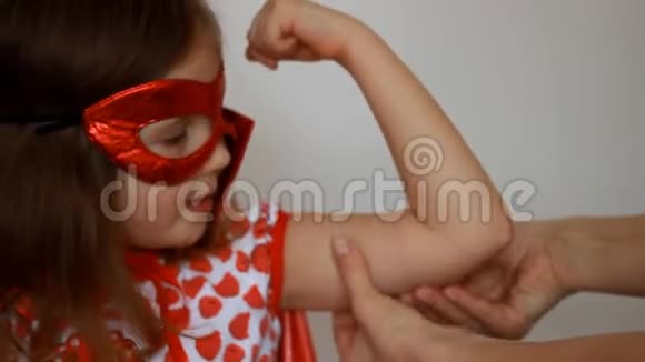 小女孩扮演超级英雄有趣的孩子穿着红色雨衣和面具玩权力超级英雄超级英雄和权力视频的预览图