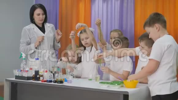 儿童化学实验孩子们手里拿着一条长长的绿色蠕虫房间里弥漫着人造烟雾视频的预览图