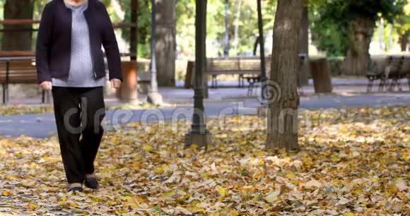 在公园散步时膝盖疼的老女人视频的预览图