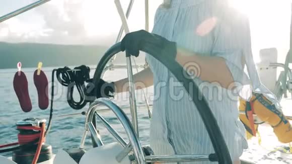 一个女人在游艇上掌舵女人在帆船上游艇在夏天旅行视频的预览图