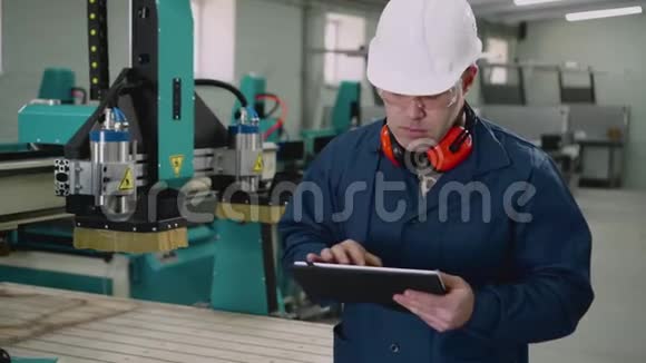 一名男性工厂工人在车间使用平板电脑视频的预览图