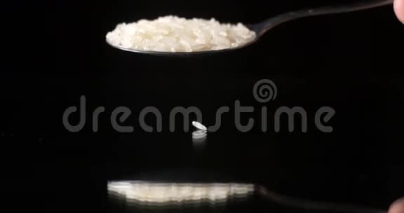 黑色背景反射桌面上落下的生米粒视频的预览图