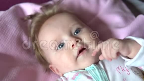 婴儿躺在床上微笑把脸贴紧视频的预览图
