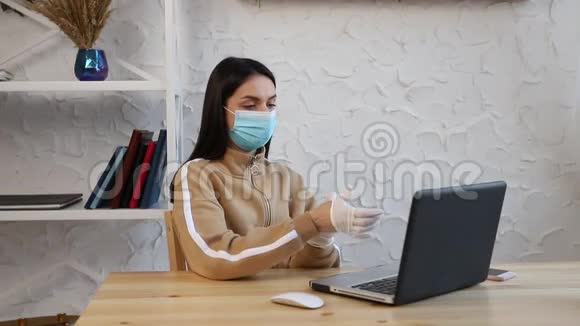 一个年轻的女孩戴着防护医疗面罩和手套在COVID19检疫期间工作视频的预览图