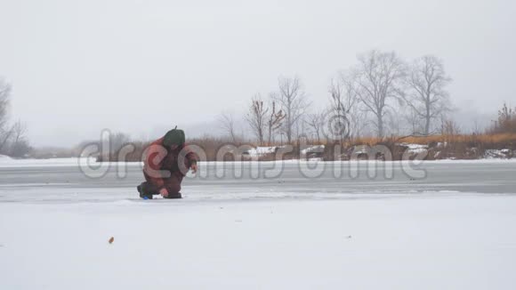 渔夫坐在结冰的河面上捕鱼视频的预览图