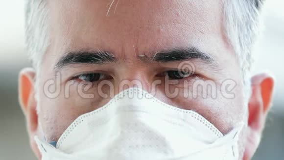 一个戴着防护面具的成熟男人的肖像向下看担心电晕病毒的概念视频的预览图