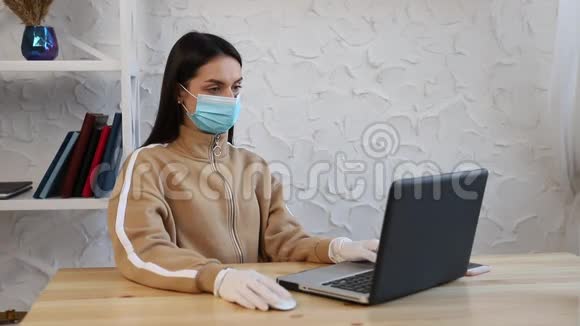 一个年轻的女孩戴着防护医疗面罩和手套在COVID19检疫期间工作视频的预览图