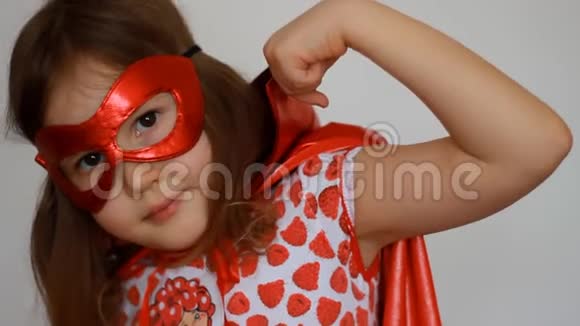 可爱的女婴扮演超级英雄有趣的孩子穿着红色雨衣和面具玩权力超级英雄超级英雄和权力视频的预览图