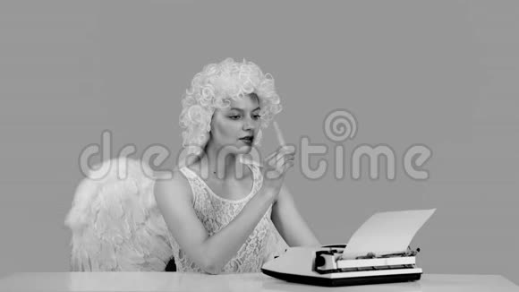 情人节一个天使正在写一封信又黑又白漂亮的年轻性感女人打字信视频的预览图