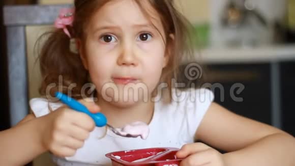 婴儿食品可爱的女孩在厨房里吃奶酪儿童早餐吃酸奶的肖像视频的预览图