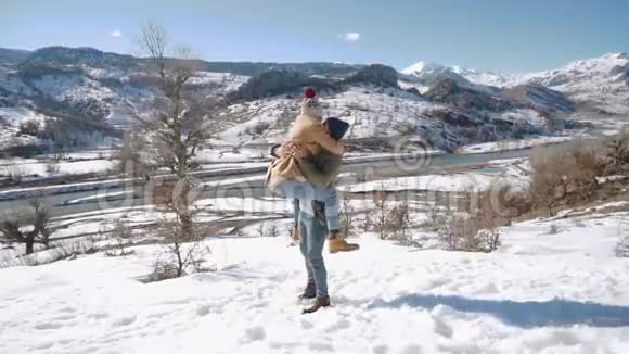 一对年轻漂亮的夫妇在一个阳光明媚的日子里在雪山上玩得很开心寒假概念视频的预览图