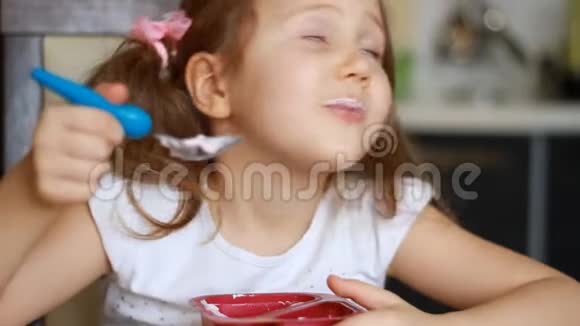 有趣的女婴在厨房里吃奶酪儿童早餐吃酸奶的肖像视频的预览图