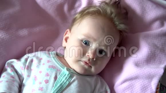 婴儿躺在床上微笑把脸贴紧视频的预览图