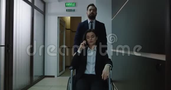 轮椅经理在办公室走廊打电话视频的预览图