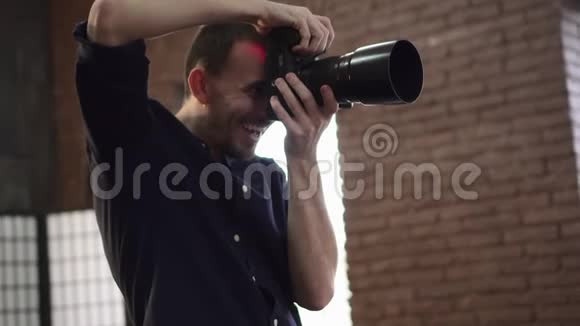 一位年轻的男性摄影师正在摄影棚里拍摄一个模特视频的预览图