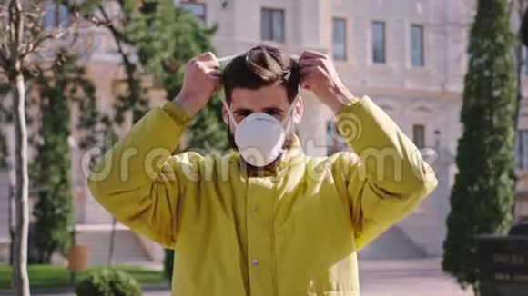 一名男子在街中央的肖像将防护面罩戴在脸上这是新的冠状病毒概念视频的预览图