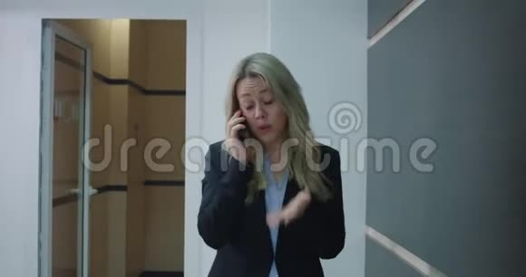 商务女性在办公室走廊打电话视频的预览图