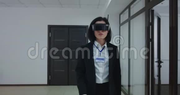 办公室走廊上戴VR眼镜的女商人视频的预览图