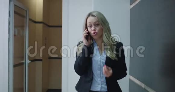 商务女性在办公室走廊打电话视频的预览图