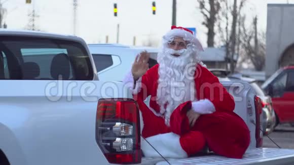 圣诞老人正在一辆小卡车后面跳舞在汽车经销商的圣诞老人视频的预览图