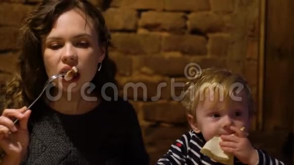 年轻女子带着小男孩在餐馆酒吧吃鲜肉视频的预览图