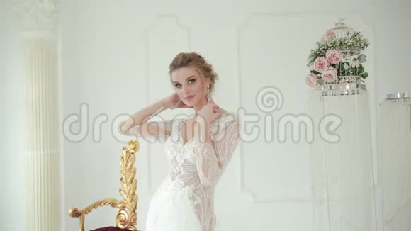 身穿白色婚纱的金发新娘摆姿势拍照用手指抚摸对方视频的预览图