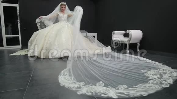 年轻漂亮的新娘穿着白色婚纱玩面纱把它推向视频的预览图