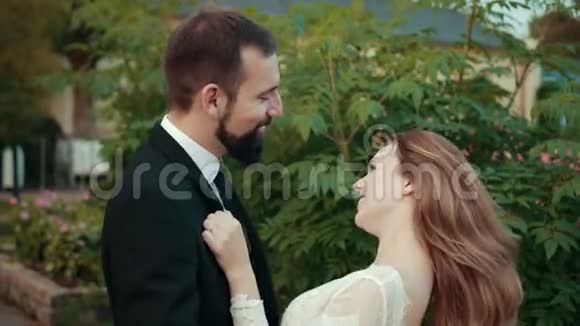 新婚夫妇相爱新娘穿着婚纱双手放在新郎的胸前视频的预览图