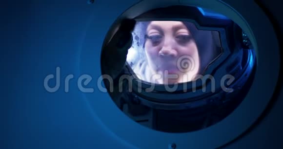 女宇航员在太空船上眺望视频的预览图