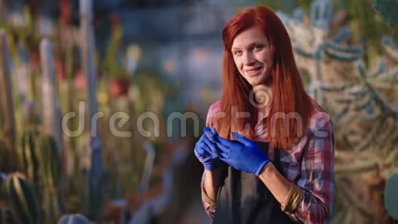 美丽的女性带着灿烂的微笑园丁在她完成她的工作后摘下手套然后交叉双手和LO视频的预览图