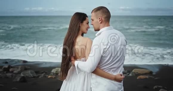 在迷人的海滨景观中浪漫的年轻夫妇有一段完美的时光他们拥抱在一起视频的预览图