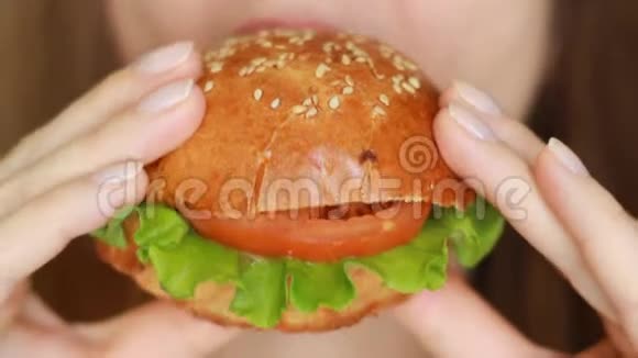 女人嘴吃素食汉堡特写镜头视频的预览图
