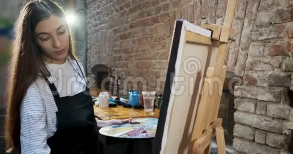 才华横溢的创新漂亮的女艺术家用画笔绘制画布当代女画家视频的预览图