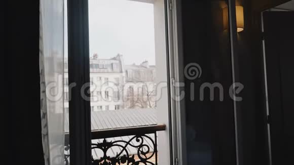 年轻快乐的旅游女性走上打开阳台的窗户享受阳光明媚的早晨巴黎埃菲尔铁塔景的慢动作视频的预览图