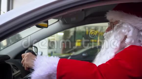 有趣的圣诞老人坐在车里汽车经销商的圣诞老人视频的预览图