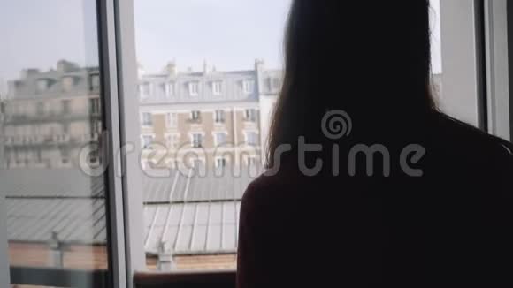 年轻快乐美丽的白种人艺术家女人走到阳台的窗户享受阳光明媚的埃菲尔铁塔景物缓慢的运动视频的预览图