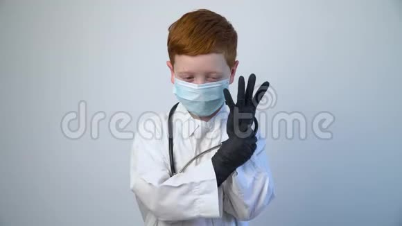 用保护面罩的听诊器关闭白种人的小医生光秃秃的医生穿上黑色的防护衣视频的预览图