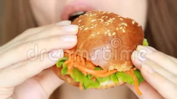 在快餐厅中关闭饥饿的年轻女子咬纯素无肉汉堡视频的预览图