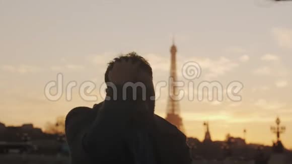 令人惊叹的日落肖像浪漫游客男子环顾四周触摸头发兴奋的巴黎埃菲尔铁塔缓慢运动视频的预览图