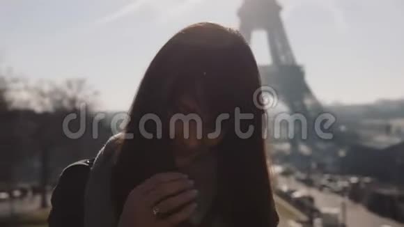 美丽快乐的白种人博客女性摆姿势微笑着在著名的巴黎埃菲尔铁塔全景慢速运动视频的预览图