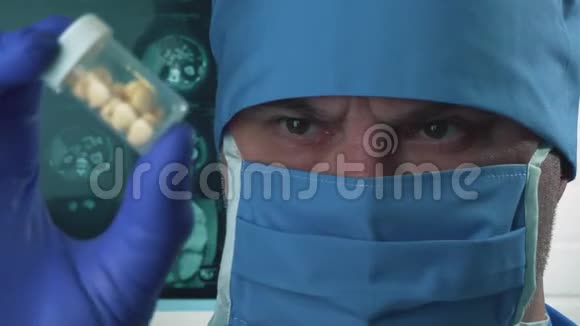 戴防护口罩和帽子的医生手里拿着药丸医学和科学研究1视频的预览图