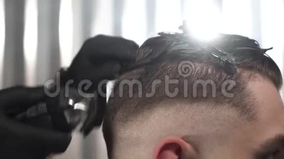 特写镜头剪子剃掉理发店里一个男人的后脑勺戴黑色手套的理发师或理发师视频的预览图