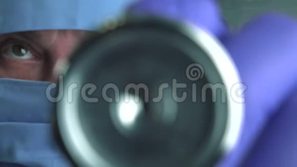 医生在临床上使用听诊器进行保护性医疗面罩听心跳和肺功能近景视频的预览图