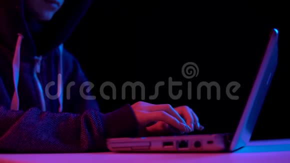 戴着笔记本电脑的女青年黑客通过笔记本电脑进行黑客攻击蓝色和红色的光落在一个女人身上视频的预览图