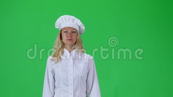 金发厨师穿着白色制服戴着顶绿色屏幕的帽子慢动作视频的预览图