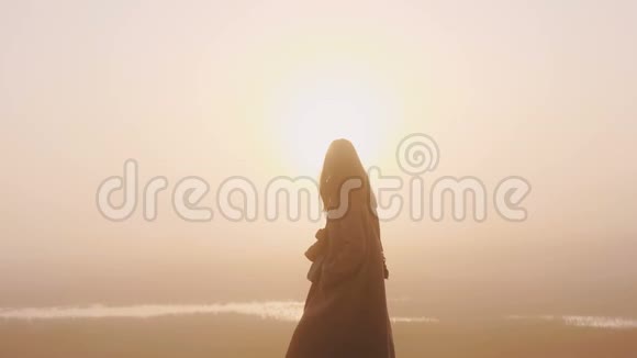 令人惊叹的抽象背景拍摄快乐的女人与相机走在惊人的粉红色雾日落观慢动作视频的预览图
