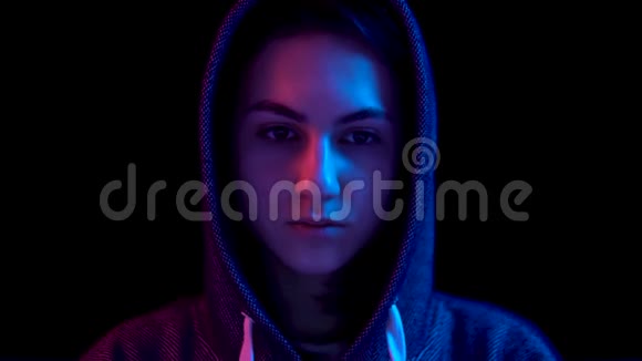 戴着笔记本电脑的女青年黑客通过笔记本电脑进行黑客攻击蓝色和红色的光落在一个女人身上视频的预览图
