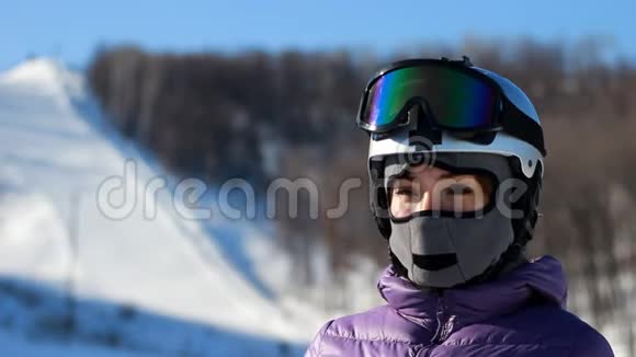 戴着头盔戴着面罩的女人戴上墨镜准备滑雪登山滑雪视频的预览图