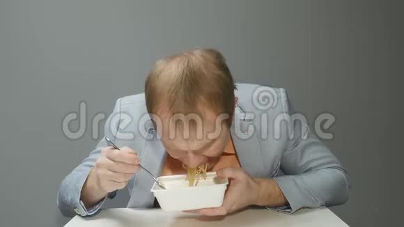 一个年轻人很快就用叉子吃面条他很饿很快就嚼了起来把肉汤喝完了视频的预览图